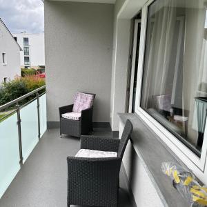balcón con 2 sillas y ventana en GL Single Town Apartment, en Wiesbaden