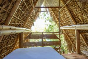 Cette chambre comprend un lit dans une cabane de paille. dans l'établissement Posada Corazon Mazunte - Natural Vibe Satori, à Mazunte