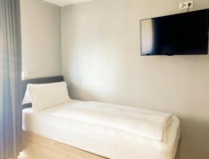 Zimmer mit einem Bett und einem Flachbild-TV an der Wand in der Unterkunft Louis Hotels in Schmitten