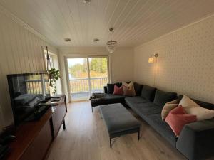 a living room with a couch and a tv at Beautiful Private Villa with Lake View and Boat in Hålland