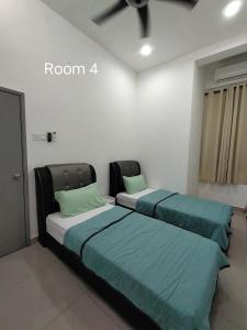 two beds in a room with green pillows at V-Homestay Bentong in Bentong