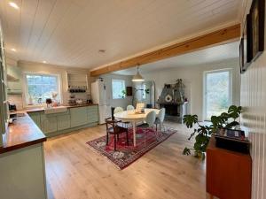 a kitchen with a table and chairs in a room at Beautiful Private Villa with Lake View and Boat in Hålland