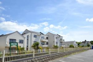 una fila de casas blancas detrás de una valla en A charming 2 bed apartment overlooking the estuary, en Instow