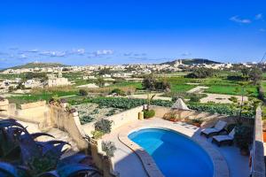 a swimming pool with a view of a city at Mill House in Għarb