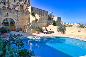 a swimming pool in front of a building at Mill House in Għarb