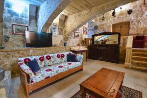 a living room with a couch and a television at Mill House in Għarb