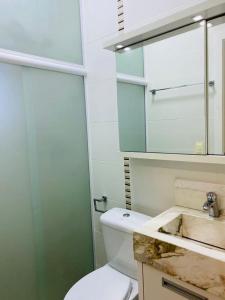 a bathroom with a white toilet and a sink at Casa à 3km da praia de Balneário Camboriú in Camboriú
