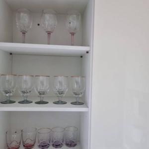 una fila de copas de vino sentadas en un estante en Our House Near Songtan Station en Pyeongtaek