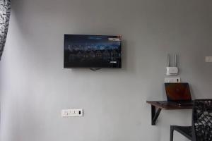 uma televisão de ecrã plano pendurada numa parede branca em Compact yet beautiful 1bhk 402 em Bangalore