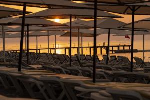 eine Gruppe von Stühlen und Sonnenschirmen am Strand in der Unterkunft L'Oceanica Beach Resort in Kemer