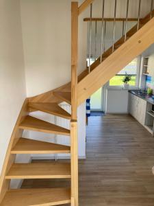 a wooden staircase in a house with a kitchen at Sofia Dwupoziomowe Apartamenty in Jarosławiec