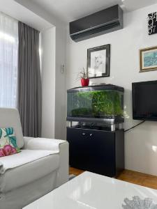 ein Wohnzimmer mit einem Aquarium und einer Couch in der Unterkunft SASE Apartment in Sarajevo
