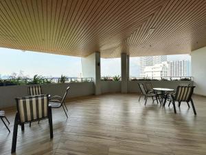 a room with chairs and a table with a view of a city at JZstay - Atlantis Residences Melaka - 1BR & 2BR in Melaka