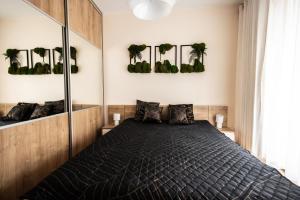 a bedroom with a bed with plants on the wall at Apartament przy bulwarach w Straconce in Bielsko-Biala
