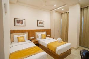 a hotel room with two beds and a window at The Triana in Varanasi