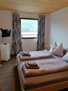 - une chambre avec un grand lit et une fenêtre dans l'établissement Ferienwohnung Donnerkogel, à Annaberg-Lungötz