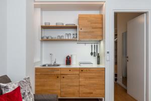 a kitchen with wooden cabinets and a sink at Syntagma Apartments by Olala Homes in Athens