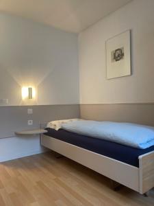 een kleine slaapkamer met een bed en een tafel bij Hôtel les Berges in Chippis