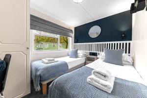 a bedroom with two beds and a window at Firgarth Lodge in Windermere