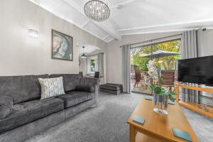 a living room with a couch and a tv at Firgarth Lodge in Windermere