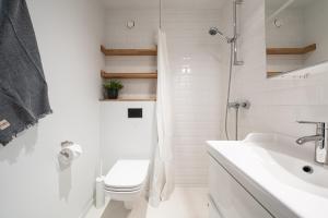 Dream Stay - Mere Residence Apartments with 24H reception في تالين: حمام ابيض مع مرحاض ومغسلة