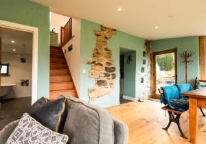 a living room with a stone wall and a table at Penrhiw - a country cottage with mountain views in Newport Pembrokeshire