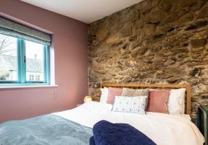a bedroom with a bed and a stone wall at Penrhiw - a country cottage with mountain views in Newport Pembrokeshire