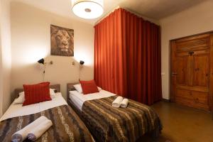 a bedroom with two beds and a red curtain at Two Wheels in Riga