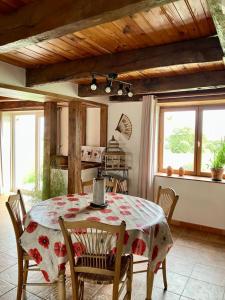 een keuken met een tafel en stoelen in een kamer bij La Jousselinie in Saint-Auvent