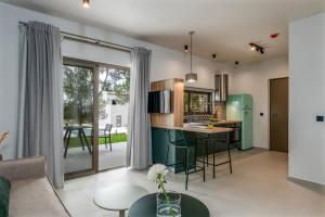 una cucina e un soggiorno con armadi verdi di Alekos Beach Houses-Akrotiri Suites a Kounopetra
