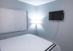 een slaapkamer met een bed en een flatscreen-tv bij Elegant 3 Bedroom Apartment In Mid West in New York