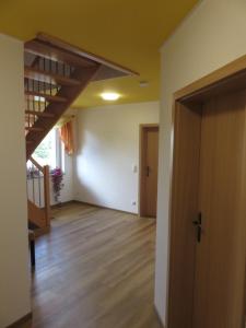 ein leeres Zimmer mit einem Flur mit Holzboden in der Unterkunft Haus am Park in Thallwitz