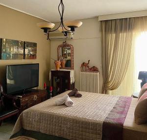 a bedroom with a bed and a flat screen tv at top8 view in Tríkala