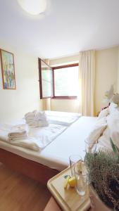 a bedroom with a large white bed with a table at Wellness Hotel Ambra in Luhačovice