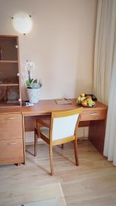 un escritorio de madera con una silla y un bol de fruta en Wellness Hotel Ambra, en Luhačovice