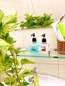 a bathroom with two bottles of soap and plants at My Kim Hotel - Ngay Bến Ninh Kiều in Can Tho