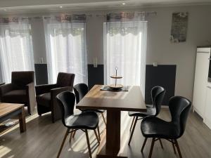 een eetkamer met een tafel en zwarte stoelen bij Apartment Kayley in Medebach