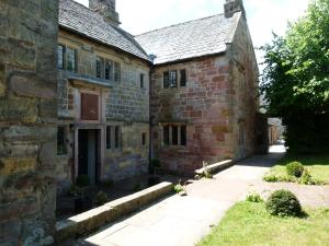 an old stone building with a courtyard in front of it at The Hall in Penrith