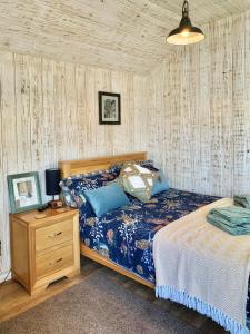 a bedroom with a bed and a night stand at Holiday Lodges with hot tub & Cosy Cabins - Greenway Farm, Drybrook, Forest of Dean in Drybrook