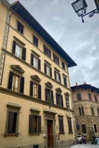 a large yellow building with windows and a castle at Hotel Cimabue in Florence