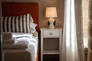 a bed with a lamp on a nightstand next to a window at Della Croce Bed&Breakfast in Svetvinčenat