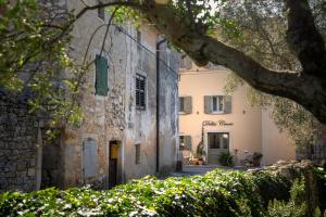 an old stone building with a tree in front of it at Della Croce Bed&Breakfast in Svetvinčenat