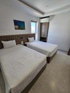 1 dormitorio con 2 camas y ventana en Country House en Quy Nhon