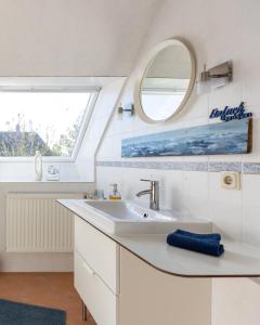 een badkamer met een wastafel en een spiegel bij Leichtes Gepäck in Pellworm