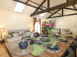 a living room with a wooden table with plates and flowers at Moor Farm Cottage in Chesterfield