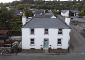 ein weißes Haus mit schwarzem Dach in der Unterkunft Luxury Scottish Hot Tub Getaway in Gatehouse of Fleet