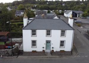 a white house with a black roof at Luxury Scottish Hot Tub Getaway in Gatehouse of Fleet