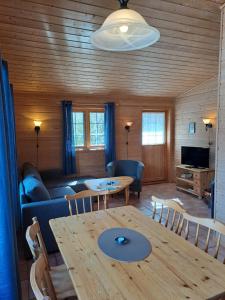 a living room with a table and a couch at Stardalen Hyttegrend in Klakegg