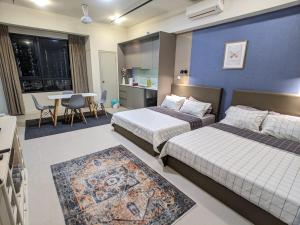 um quarto de hotel com duas camas e uma mesa e cadeiras em Tamarind Suites OR Domain NeoCyber, click room first for pics em Cyberjaya