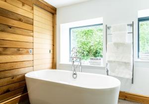 a white tub in a bathroom with a window at Panteg - a gorgeous retreat near the coast for 10 in Cardigan